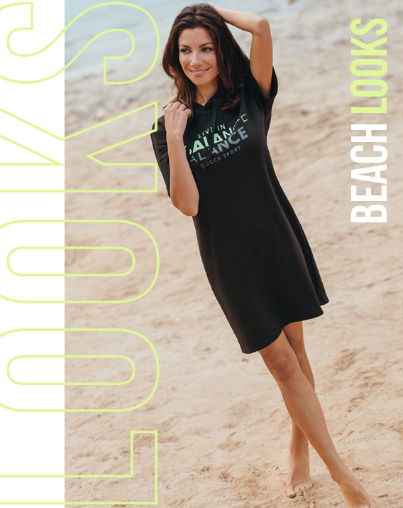 Model trägt schwarzes Kleid am Strand