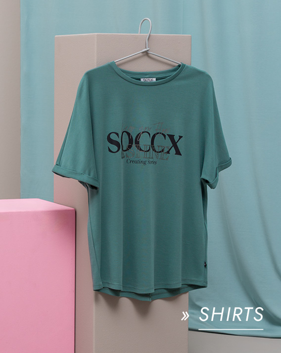 Grünes T-Shirt hängt auf einem Bügel