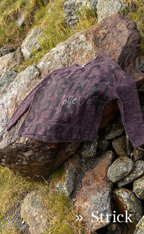Strickpullover liegend auf einem Stein