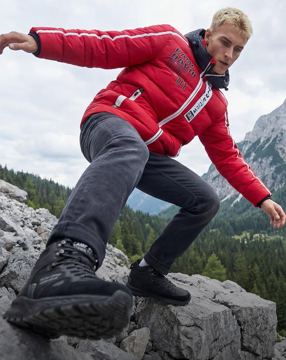 Model im Gebirge trägt Winter Outfit