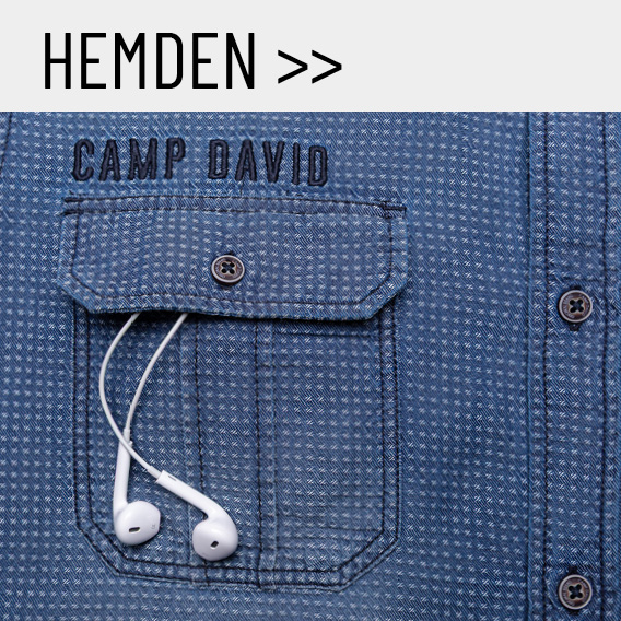 Eine Nahaufnahme von einem blauen Hemd. Aus der Tasche ragen Kopfhörer