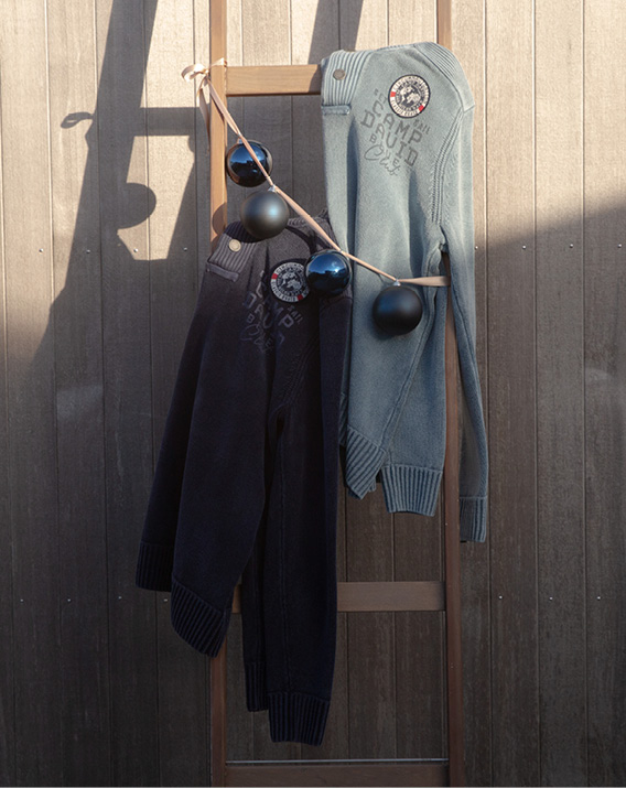 Model trägt Pullover und zieht Weihnachtsbaum