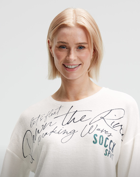 Model trägt weißen Pullover mit Print